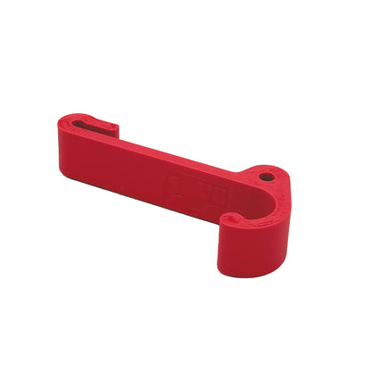 Ein robuster Multifunktionshaken in pink, eingehängt an einem Schrank im VW Grand California. Am unteren Haken hängt eine Jacke, während durch die kleine Öse auf der Rückseite eine Schnur gezogen ist, an der ein Bluetooth-Lautsprecher befestigt wurde. Der Haken fügt sich unauffällig ins Fahrzeugdesign ein und bleibt sowohl bei geöffnetem als auch geschlossenem Schrank nutzbar. Perfekt für mehr Ordnung im Camper!